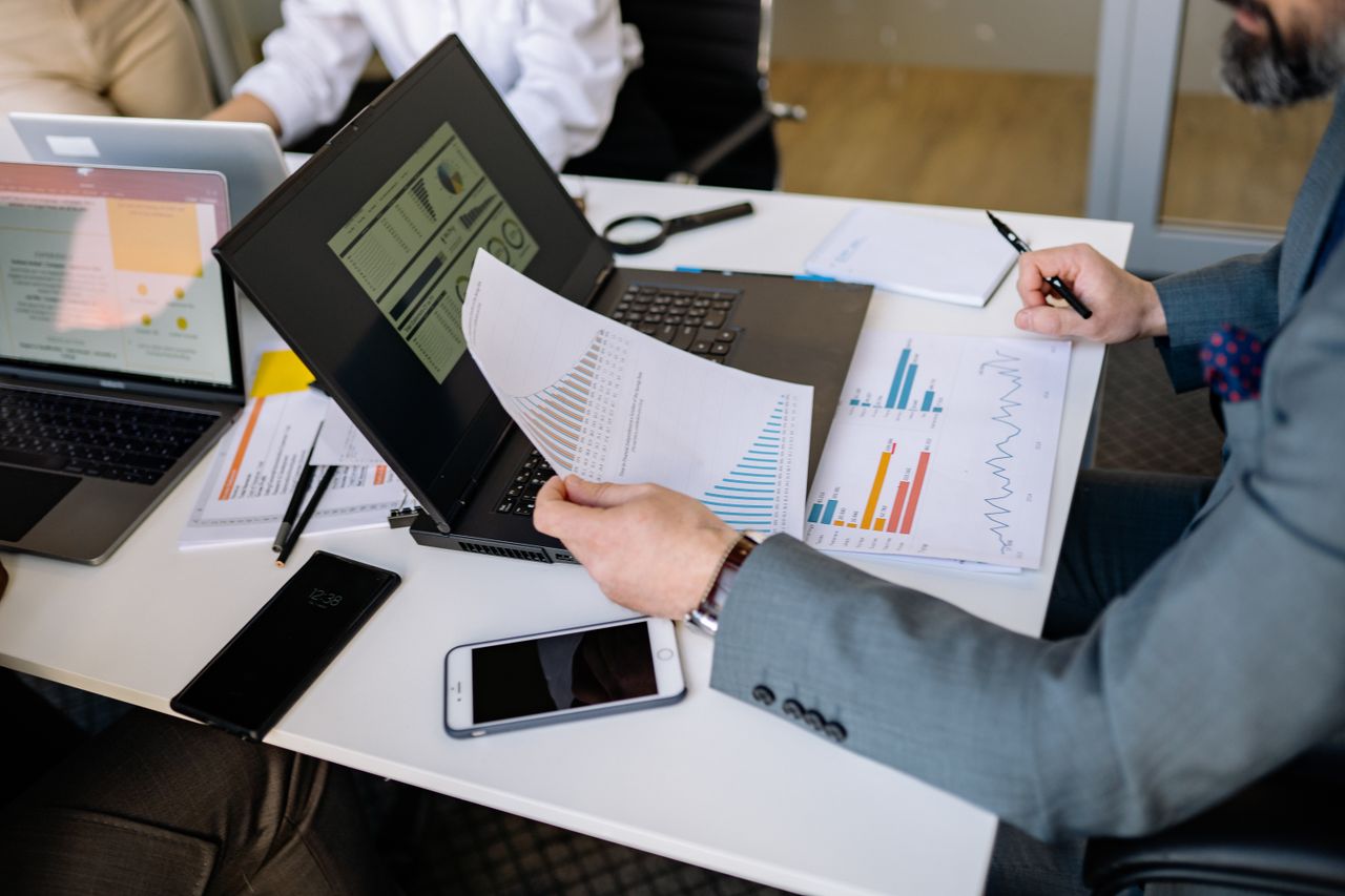 Mastering the First Impression: Your intriguing post title goes here Professionals analyzing charts and graphs on laptops during a business meeting.